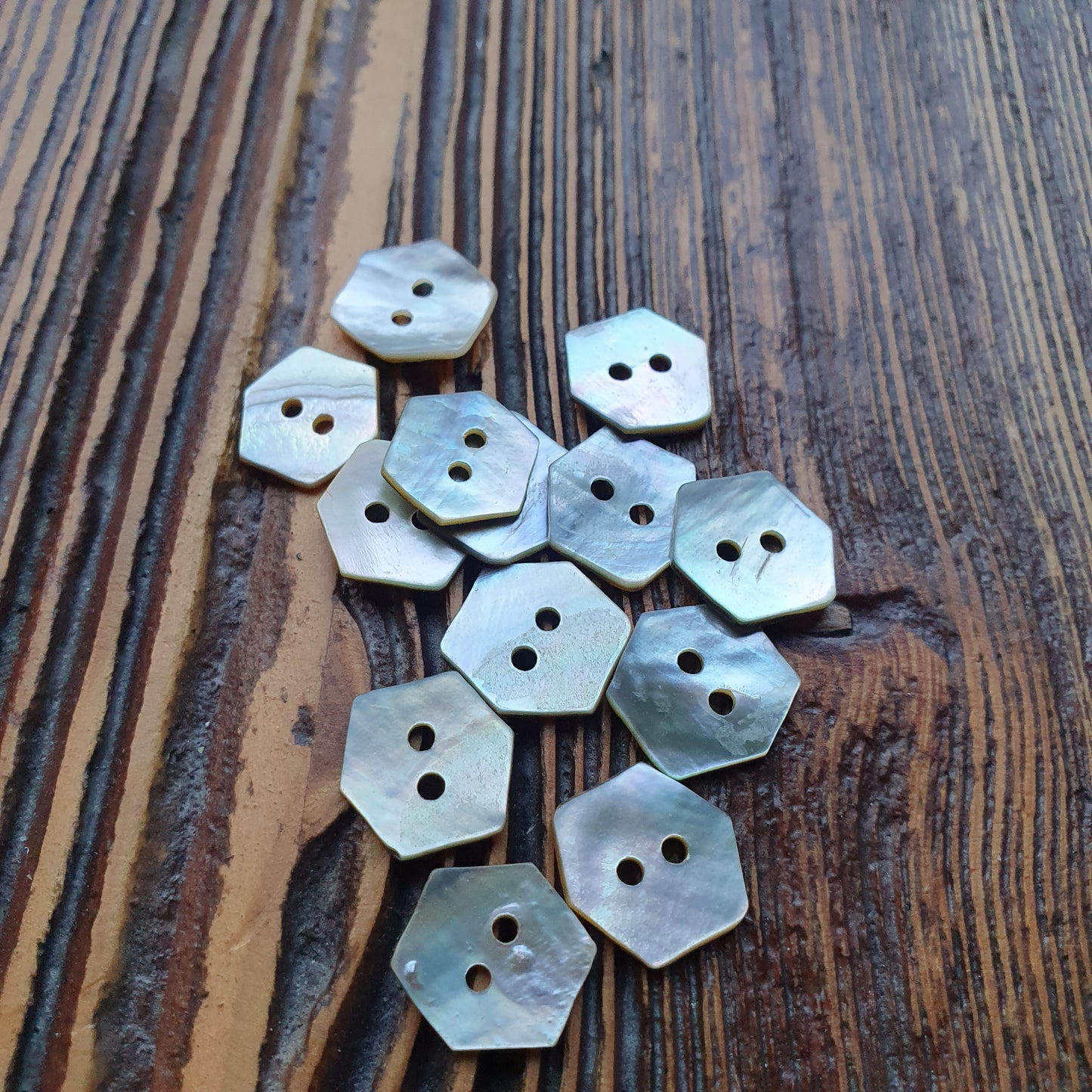 Schelpknoop 2-gaats hexagoon 15mm. Verpakt per 100 stuks.