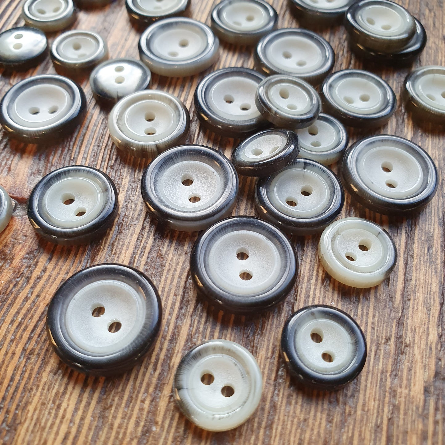 Polyester knoop / 2-gaats / Kleur: grijs-zwart / Prijs per 100 stuks.